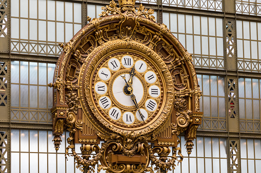 Paris, France - July 5, 2018: Golden clock of the museum D'Orsay. The Musee d'Orsay is a museum in Paris, on the left bank of the Seine. Golden colored clock inside Musee d'Orsay Museum in Paris.