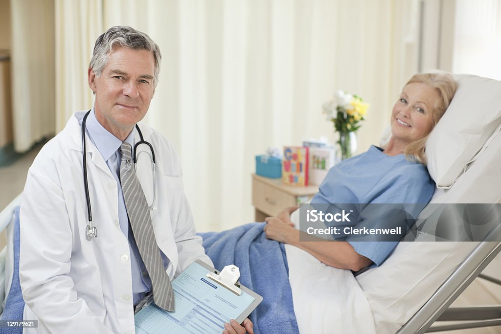 Ritratto di medico e paziente in ospedale - Foto stock royalty-free di 60-64 anni