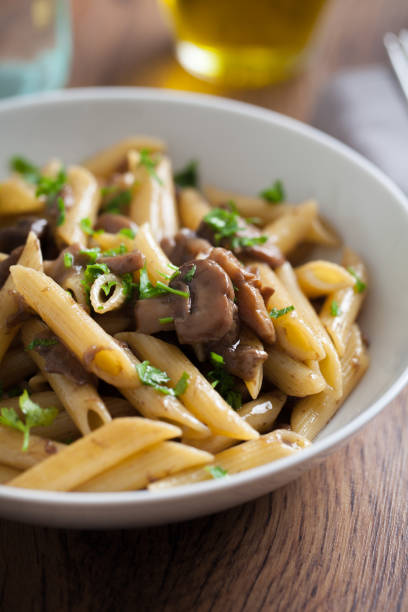istock Penne pasta with mushrooms on a plate. 1291796421