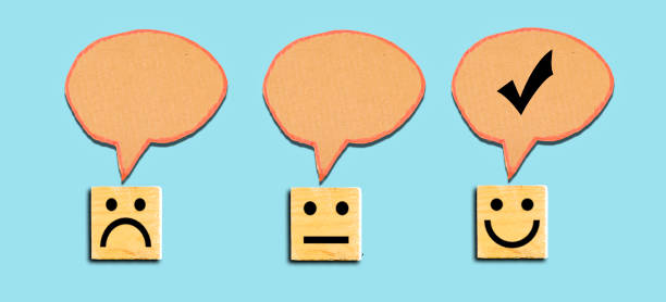 istock Customer service evaluation and satisfaction survey concepts. Face icon on wooden cube and chat bubble cardboard 1291797350