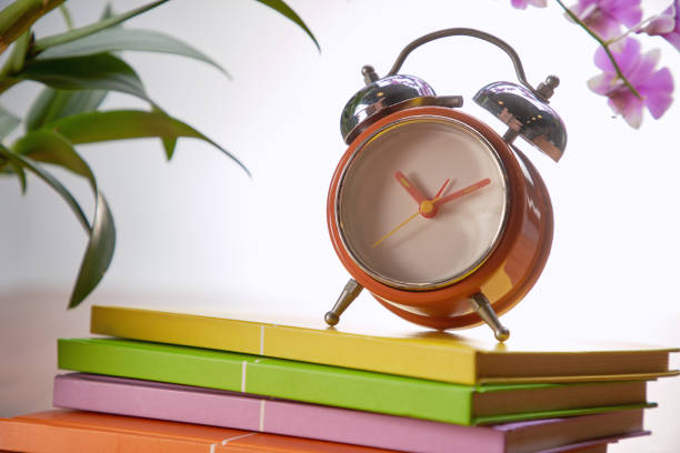 istock vintage alarm clock on stack of book 1291798510