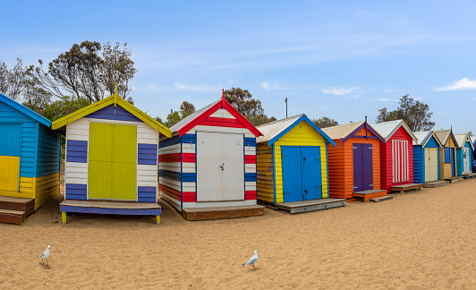 Melbourne, Australia; December 17th, 2020 - A row of colourful multi-coloured wooden beach huts at Brighton Beach, Melbourne, Victoria State, Australia