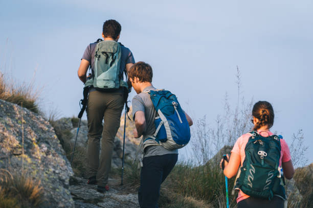 istock Friends hike along sunny mountain ridge at sunrise 1291800471