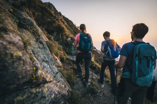 istock Friends hike along sunny mountain ridge at sunrise 1291800706