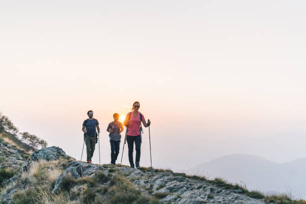 istock Friends hike along sunny mountain ridge at sunrise 1291800818
