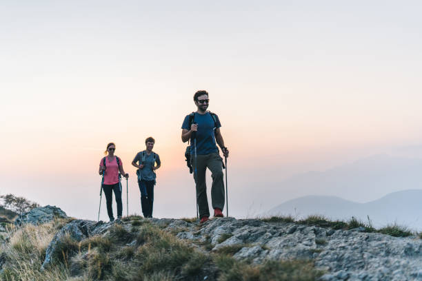 istock Friends hike along sunny mountain ridge at sunrise 1291800833