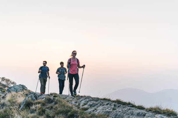 istock Friends hike along sunny mountain ridge at sunrise 1291800856