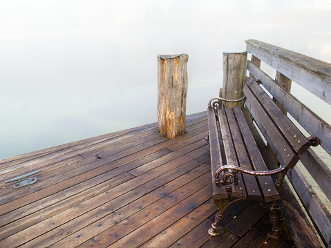 Wooden bench in fog on a pier