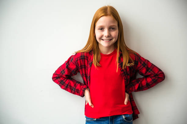 Color photo of a happy, red-haired girl smiling with upward braids! Room for text above.