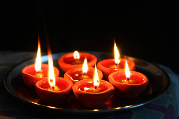 istock Burning candles and oil diya on dark background 1291803406