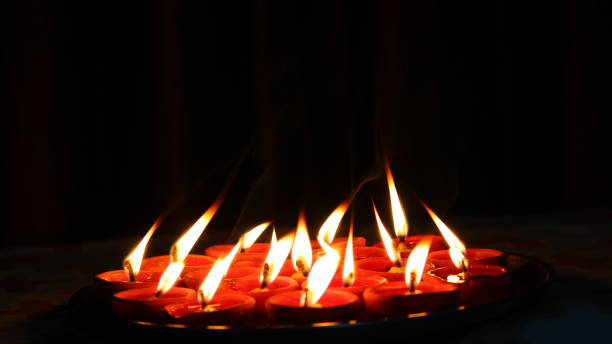 istock Burning candles and oil diya on dark background 1291804703
