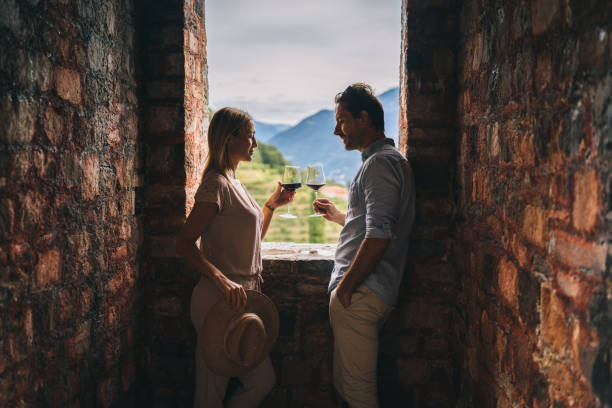 pareja disfrutar de un poco de vino tinto en el antiguo castillo italiano - glass drink alcohol red fotografías e imágenes de stock