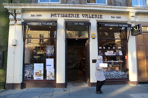 Edinburgh, Scotland - 17 December 2020 Customer holding a box of pastries outside a Patisserie Valerie pastry shop