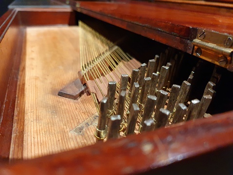 harpsichord strings close-up. the image shows the interior of an harpsichord with sveral strings.