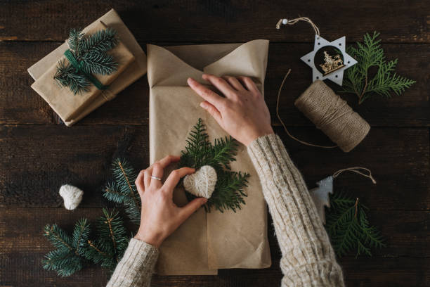 istock Giving Tuesday, Give, Help, Donation, Support, Volunteer concept with female hands wrapping craft gift box with knitted heart on wooden background 1291815642