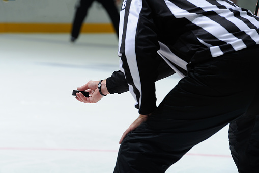 Closeup of an ice hockey referee preparing for the face off.