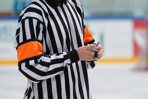 Closeup of an ice hockey referee writing notes during the game.