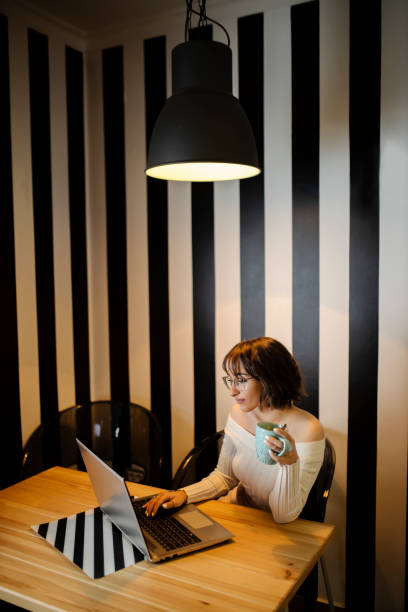 istock Young woman working at home and drinking coffee 1291817948
