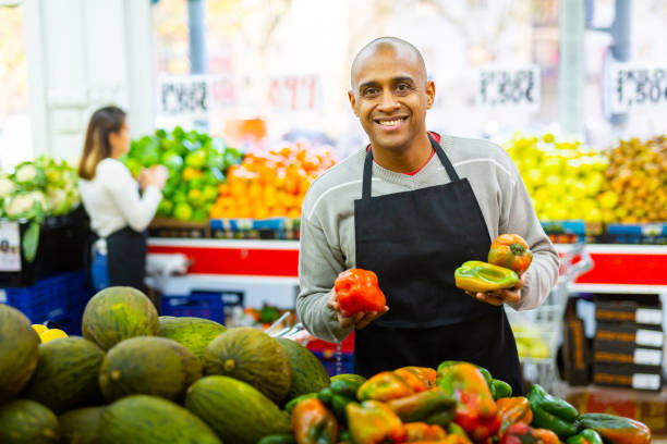istock Spanish employee in  vegetable store with sweet peppers 1291820733