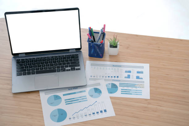 istock Laptop and papers on desk in front of window 1291821997