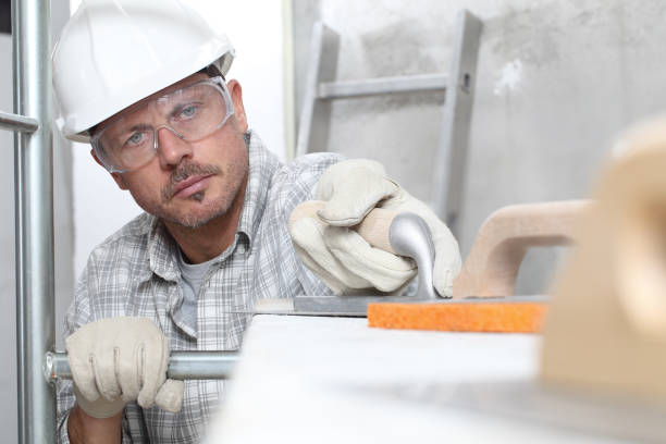 istock man work, professional construction worker  with plastering tools on scaffolding, safety hard hat, gloves and protective glasses. on interior building site background 1291824895