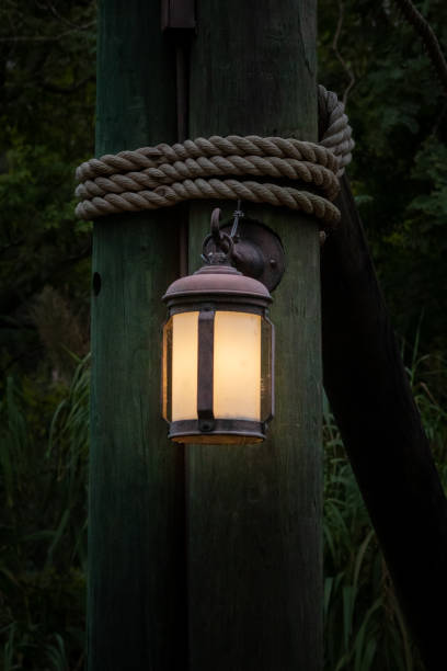 istock Lantern Hanging on a Pole with a Rope in a Forest 1291825244