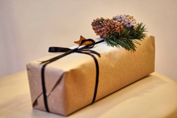 istock Craft box with black ribbon and pine cones. Christmas present. Gift wrap. 1291825420