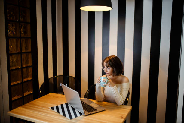 istock Young woman working at home and drinking coffee 1291828889