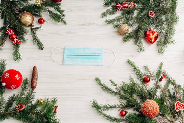 istock Christmas Composition with Mask on a White Wooden Table with Copy Space 1291829903