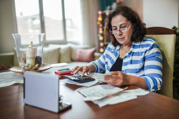 femme retraité gérant sur un revenu bas - financial burden photos et images de collection