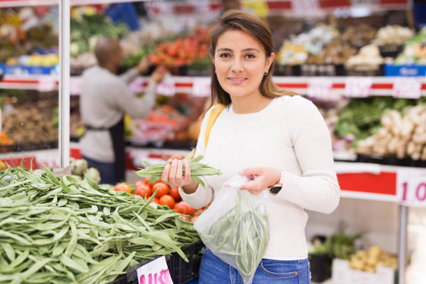 istock Female customer choosing fresh beans in shop 1291833483