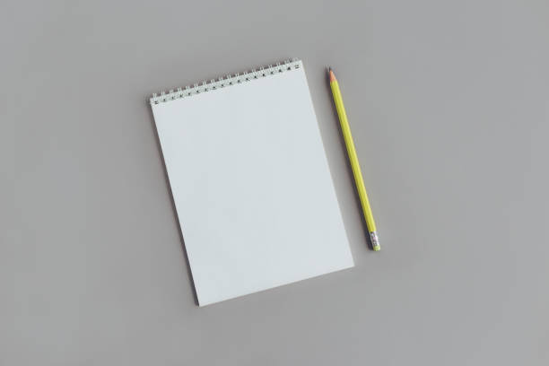 istock Notebook with blank page and yellow pencil on a grey background. 1291833988
