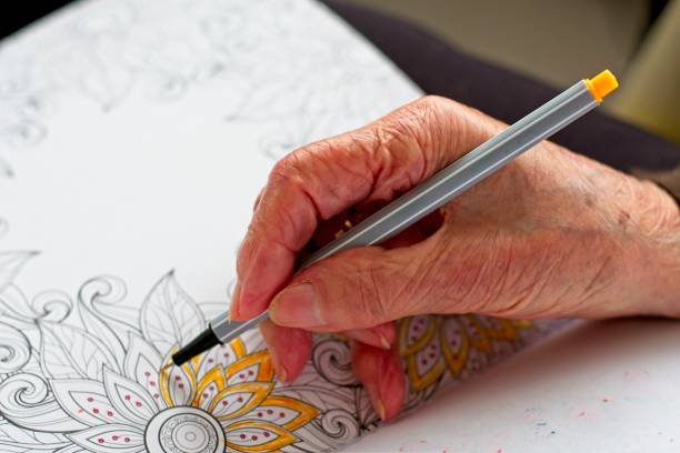 istock close-up old woman's hand coloring a drawing 1291834304