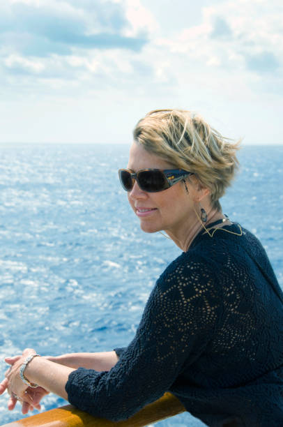 istock pretty woman on balcony looking at ocean 1291835393