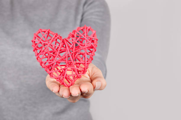 istock Hand with red heart on grey background. 1291835641