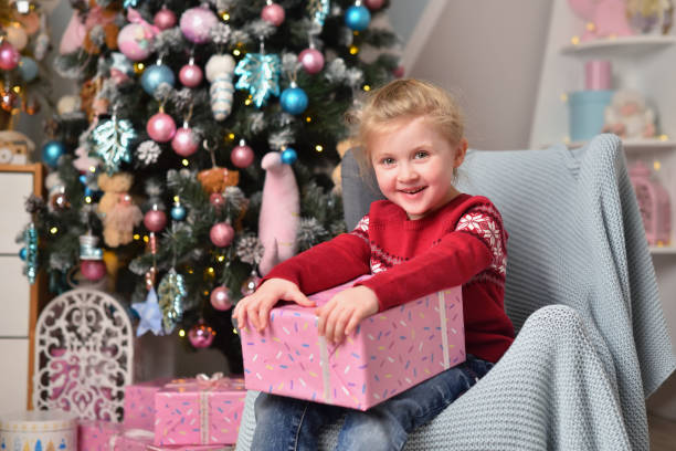 istock Smiling little girl holding christmas present in gift box 1291836295