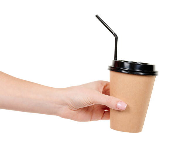 istock Hand with cardboard cup with black straw isolated on white background. 1291836578