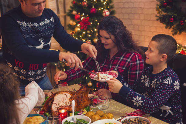 istock Young father carving stuffed roasted turkey for Christmas dinner 1291837543