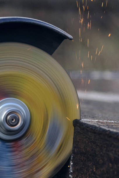 Cutting sheet steel structures an electric cut-off wheel grinding machine close-up. Sparks flying out at speed.