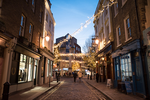 Street view at Seven Dials in the St Giles district of the London Borough of Camden in London West End with Christmas lights during the holidays