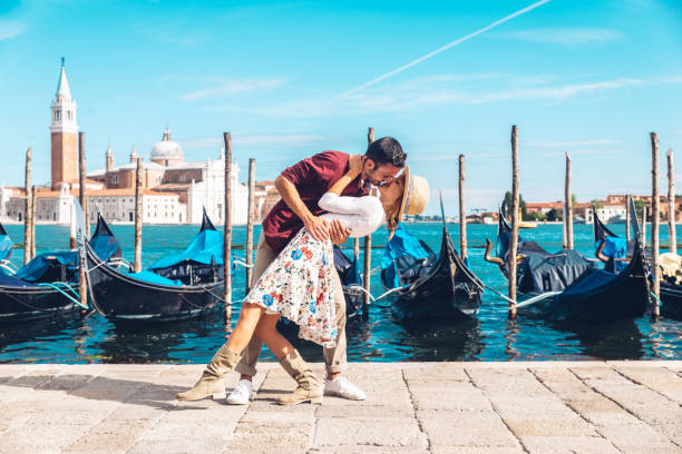 ヴェネツィアでキス愛の若いカップル - イタルト - ゴンドラ船 ストックフォトと画像