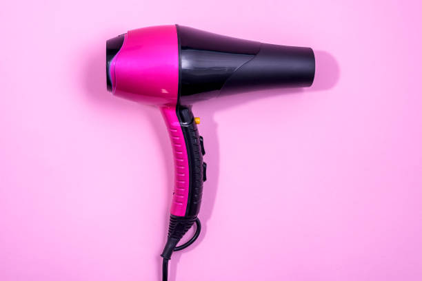 istock Hairdryer on light pink background 1291840811