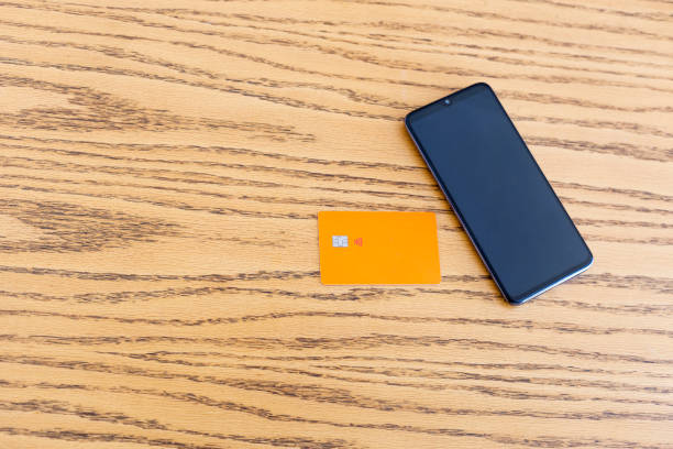 istock Smartphone and inter bank card on the wooden table 1291842308