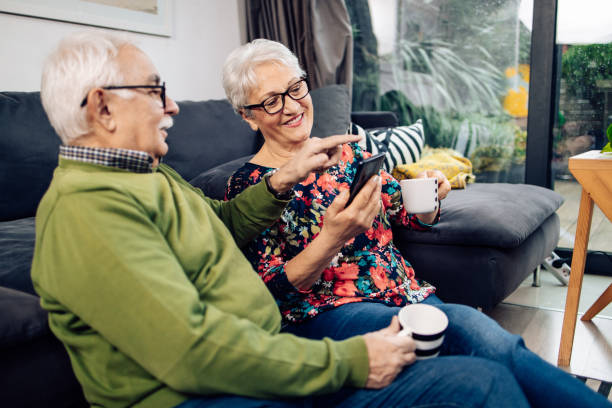istock Happy seniors using a smartphone and relaxing with coffee at home 1291842408