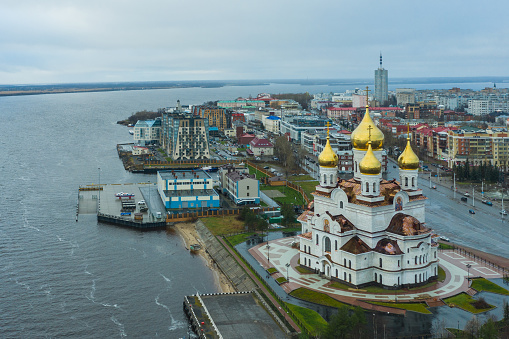 Arkhangelsk, Russia - November 6, 2020: View of the embankment of the city and church with top, in rainy weather.