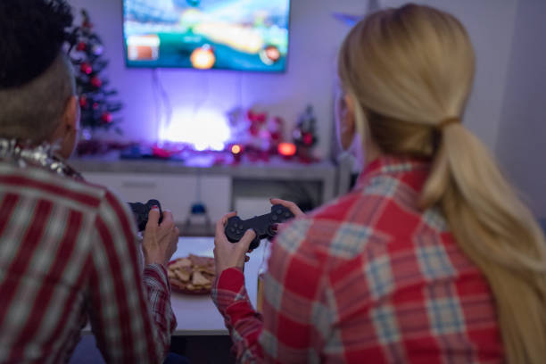 istock rear view of two women playing video game 1291851476