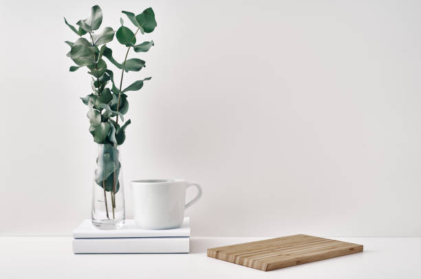 istock A mug, a stack of books, a wooden board and a transparent vase with eucalyptus branches. Eco-friendly materials in interior decor, minimalism. Copy space, mock up 1291852735