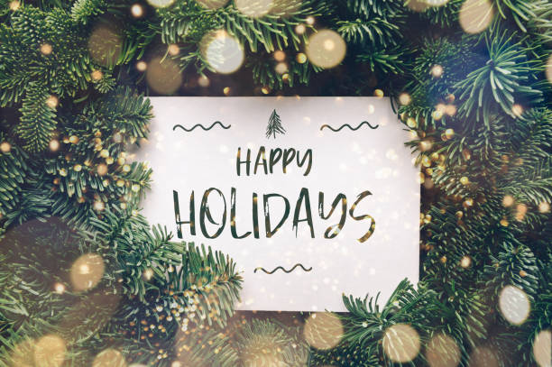 Happy Holidays card Happy holidays text, card concept. Holiday background with white card in the middle of evergreen tree branches with lights, christmas and festive season idea, minimalistic design happy holidays stock pictures, royalty-free photos & images