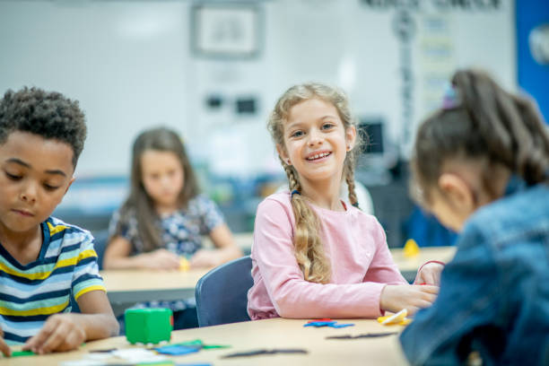 istock Elementary Caucasion girl smiling at camera in classroom 1291852911