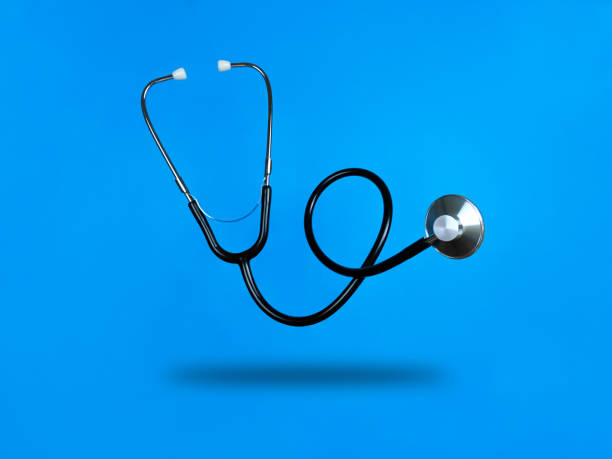 Levitating stethoscope on blue background and shadow under it. Stock photo.